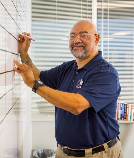 man working at a whiteboard.