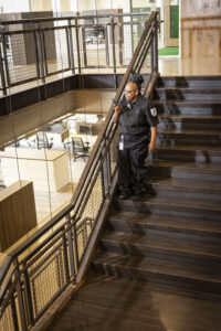 24 hour security guard in uniform walking down staircase making rounds
