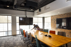 Day porter cleaning conference room in office