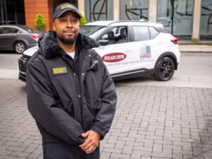 Security Guard standing in front of patrol car