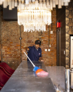 commercial cleaning company employee dusting a surface