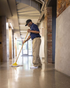 janitor mopping hallway floor