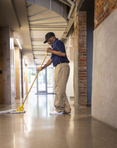 commercial cleaning staff mopping hallway floor in office