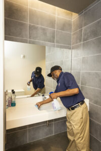 janitorial staff cleaning restroom sink
